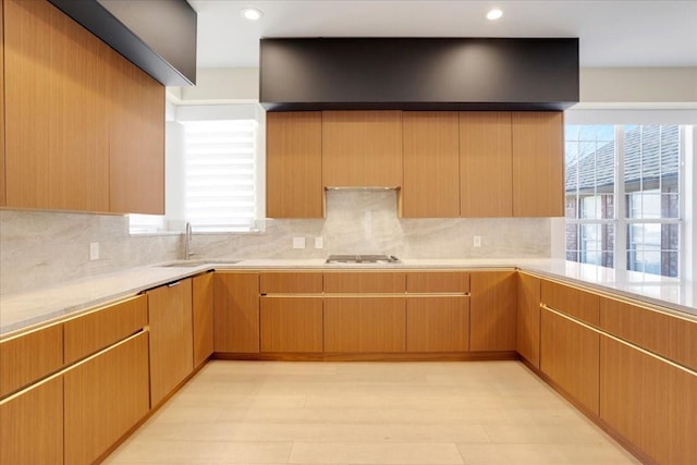 kitchen featuring backsplash, a sink, gas stovetop, and recessed lighting