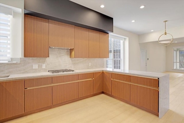 kitchen with light countertops, recessed lighting, backsplash, and stainless steel gas stovetop