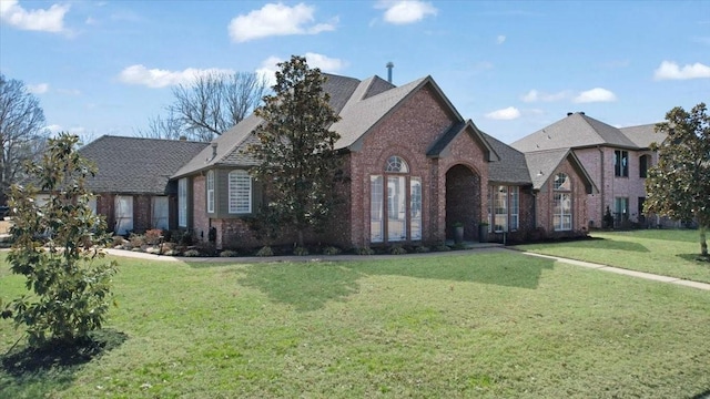 view of front of property featuring a front yard and brick siding