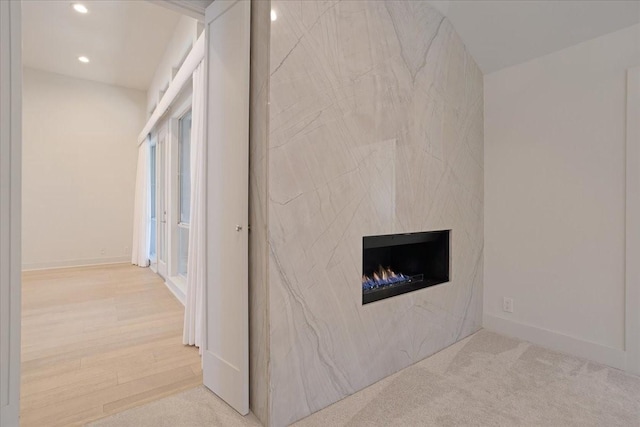 interior space with carpet floors, recessed lighting, and a premium fireplace