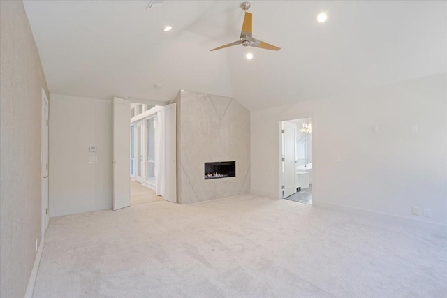 unfurnished living room featuring lofted ceiling, recessed lighting, a premium fireplace, a ceiling fan, and light carpet