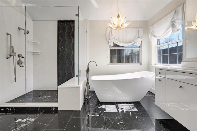 full bath featuring marble finish floor, a notable chandelier, vanity, a walk in shower, and a freestanding tub