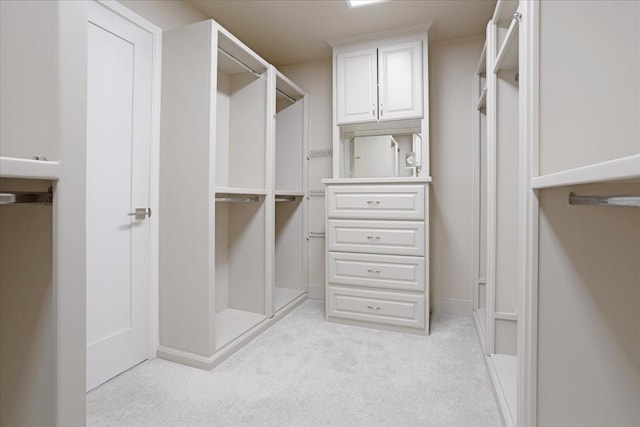 walk in closet featuring light colored carpet