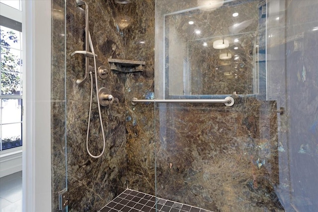 bathroom featuring a marble finish shower