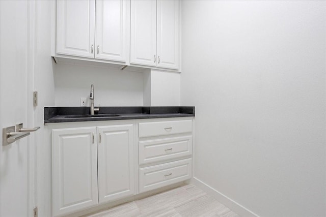 interior space with baseboards and a sink