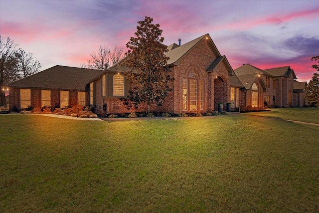 view of front of home featuring brick siding and a front yard