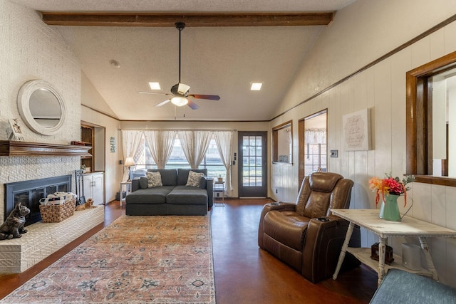 living area featuring beam ceiling, a fireplace, and a textured ceiling