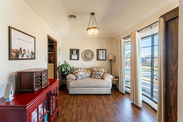 sitting room with a textured ceiling, dark wood finished floors, and visible vents