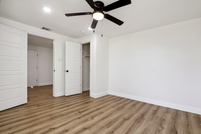 unfurnished bedroom featuring ceiling fan, light wood-style flooring, visible vents, baseboards, and a closet