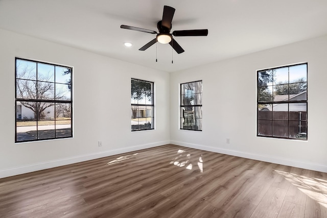 empty room featuring a ceiling fan, baseboards, wood finished floors, and recessed lighting