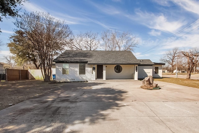 view of front of home featuring driveway, fence, and roof with shingles