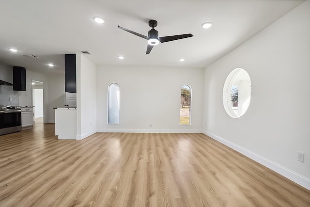 unfurnished living room with light wood-style floors, visible vents, baseboards, and a ceiling fan