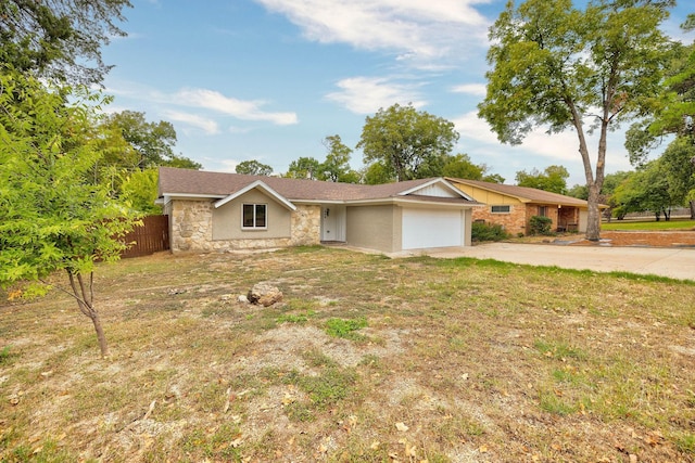 ranch-style home with concrete driveway, stone siding, an attached garage, fence, and a front lawn