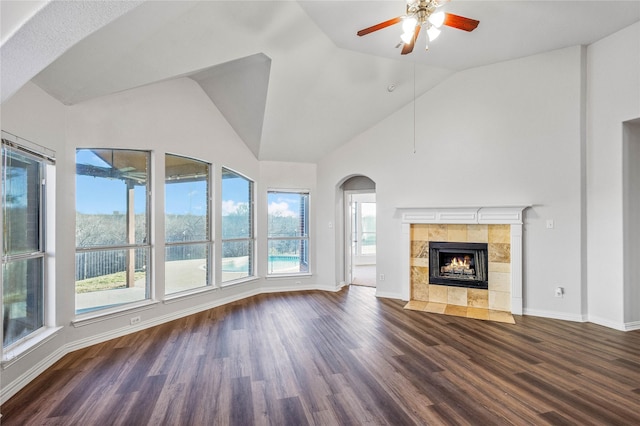 unfurnished living room with ceiling fan, baseboards, dark wood-style flooring, and a tile fireplace