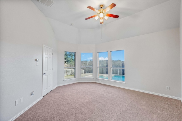 carpeted empty room with lofted ceiling, ceiling fan, visible vents, and baseboards