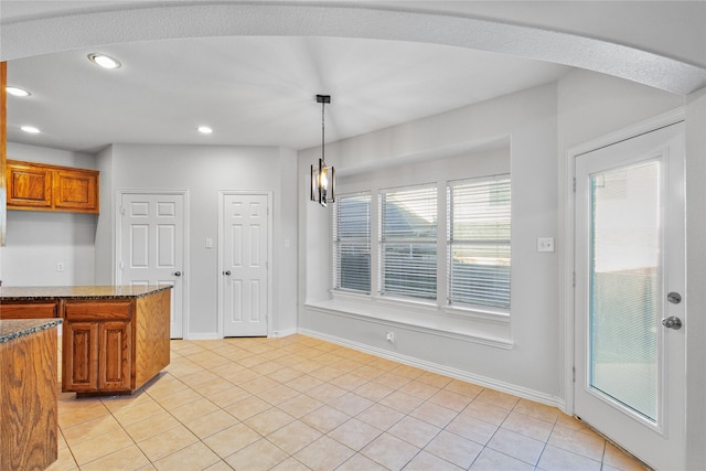 kitchen featuring light tile patterned floors, recessed lighting, baseboards, hanging light fixtures, and brown cabinets