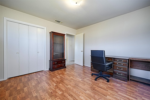 unfurnished office with light wood-type flooring and visible vents