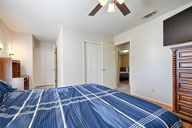 unfurnished bedroom with baseboards, visible vents, a ceiling fan, wood finished floors, and a closet