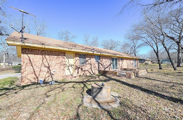 back of house with a yard and brick siding