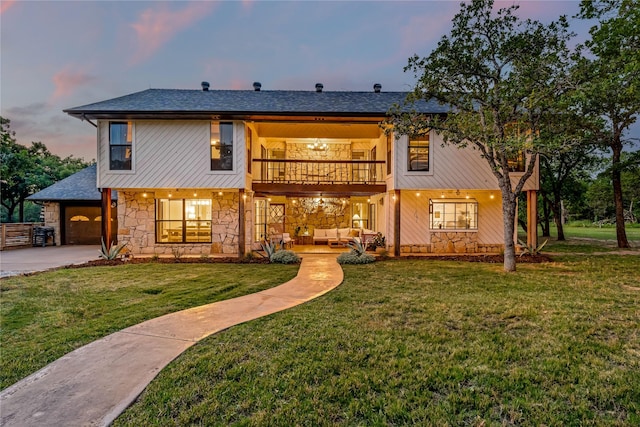 3113 Rock Creek Rd, Mineral Wells, TX 76067 - back of property at dusk with outdoor lounge area, a lawn, a balcony, stone siding, and driveway