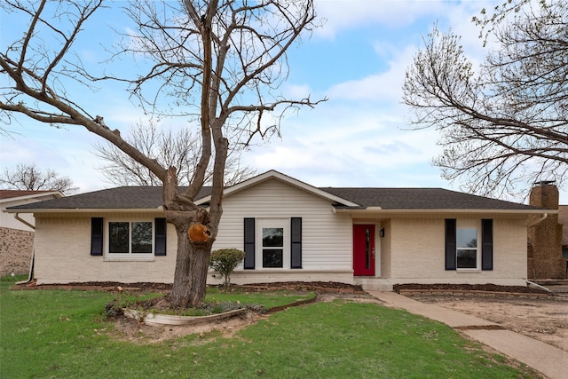 ranch-style home featuring roof with shingles, a chimney, a front lawn, and brick siding