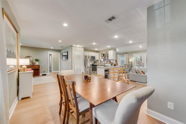 dining room featuring light wood-style flooring, visible vents, baseboards, and recessed lighting