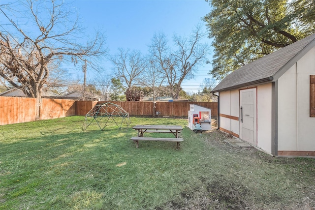 view of yard with an outbuilding, a fenced backyard, and a shed