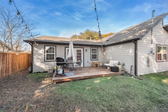 rear view of house with fence, a lawn, and a wooden deck