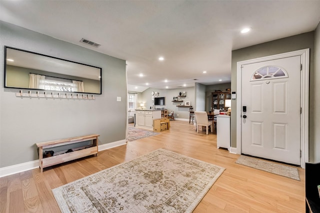 foyer featuring baseboards, light wood finished floors, visible vents, and recessed lighting