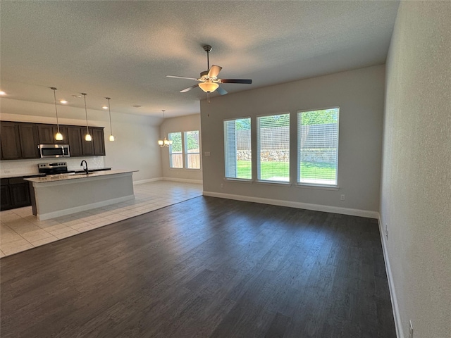 1433 Eagle Nest Dr, Pelican Bay, TX 76020 - unfurnished living room with light wood-type flooring, a ceiling fan, a textured ceiling, baseboards, and a sink