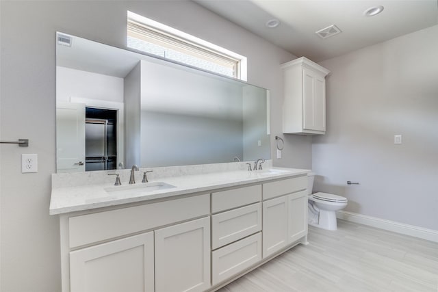 full bath with toilet, visible vents, and a sink