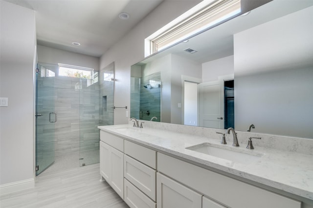 bathroom with a stall shower, visible vents, a sink, and double vanity