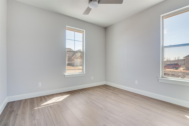 unfurnished room with light wood-type flooring, baseboards, and a ceiling fan