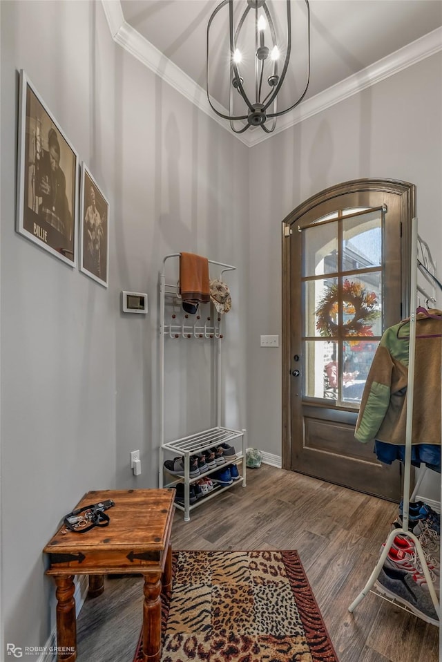 interior space with an inviting chandelier, baseboards, crown molding, and wood finished floors