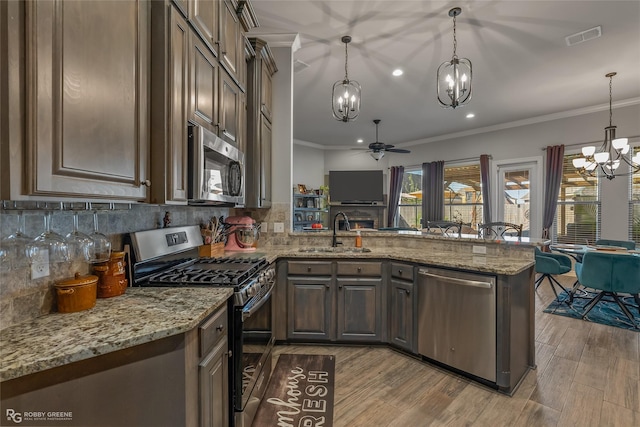 kitchen featuring appliances with stainless steel finishes, a sink, visible vents, and pendant lighting