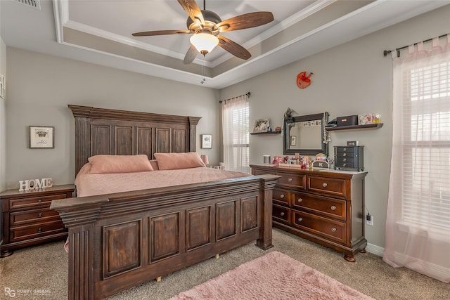 bedroom featuring light carpet, baseboards, a raised ceiling, a ceiling fan, and ornamental molding