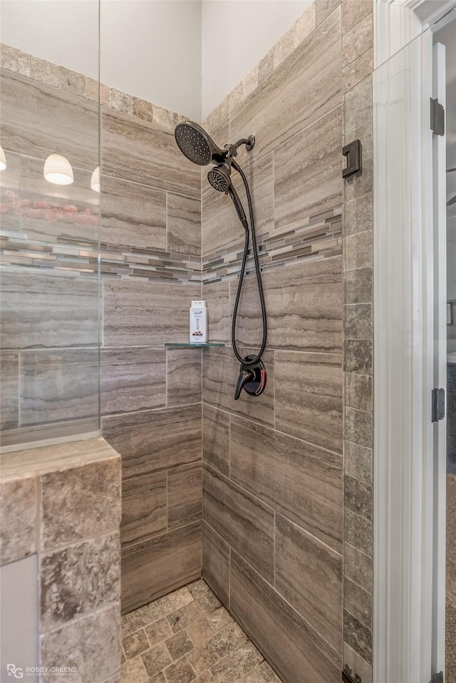 full bath with stone finish flooring and tiled shower