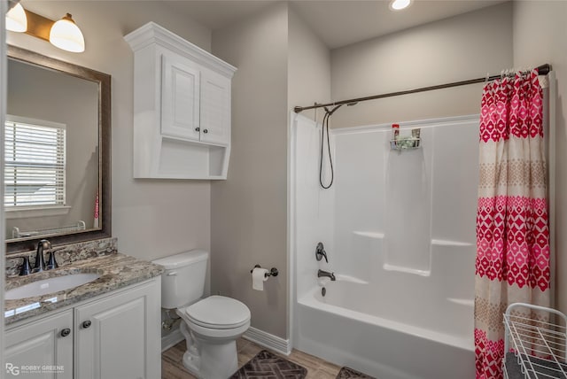 bathroom featuring toilet, shower / bath combo with shower curtain, vanity, wood finished floors, and baseboards