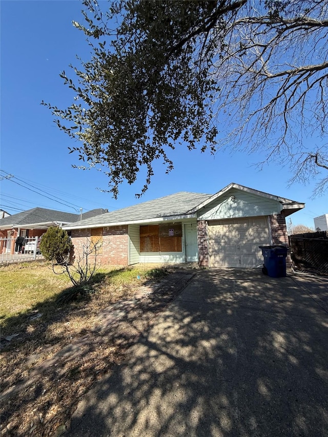 view of side of home featuring aphalt driveway, brick siding, and a garage