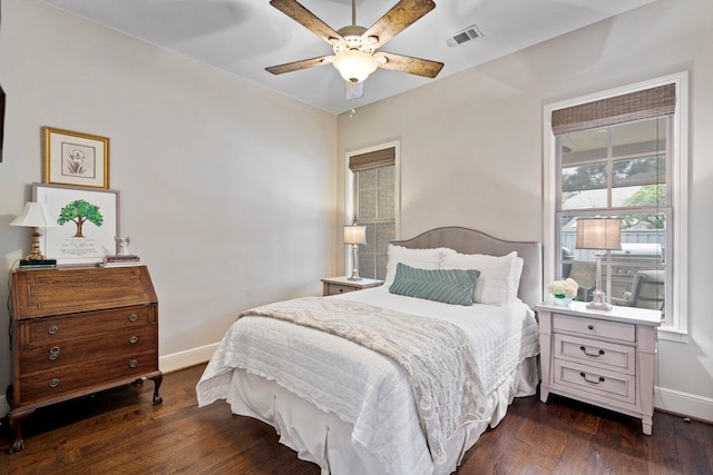 bedroom featuring baseboards, visible vents, dark wood finished floors, and a ceiling fan