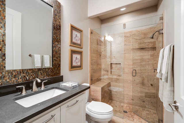 bathroom featuring a stall shower, backsplash, vanity, and toilet