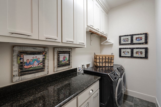 washroom with cabinet space, washing machine and dryer, and baseboards