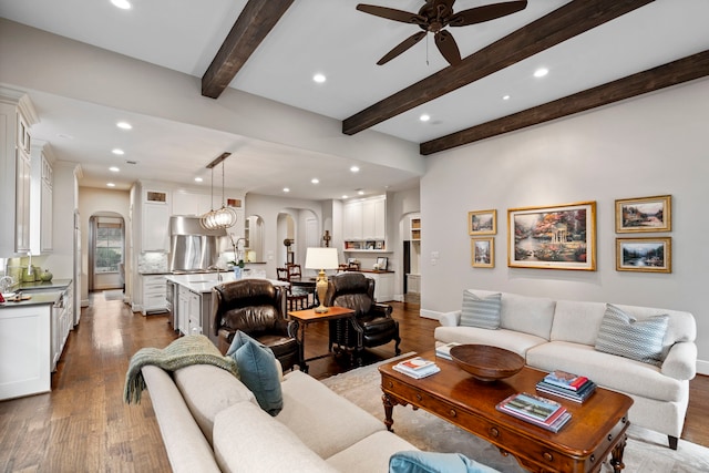 living room featuring arched walkways, recessed lighting, wood finished floors, a ceiling fan, and beam ceiling