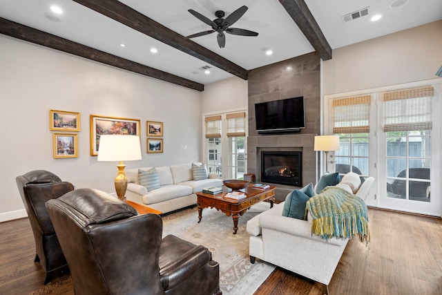 living area with visible vents, dark wood finished floors, and a tile fireplace