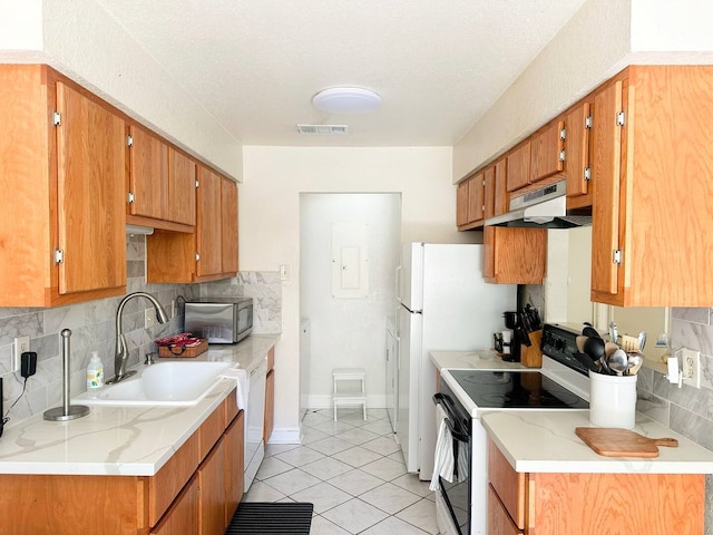 kitchen featuring light countertops, range with electric cooktop, brown cabinetry, and under cabinet range hood