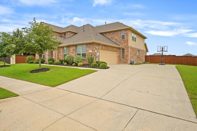 traditional-style home with concrete driveway, fence, brick siding, a garage, and a front yard