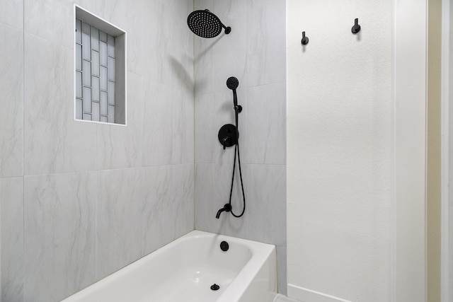 bathroom featuring a textured wall and bathing tub / shower combination