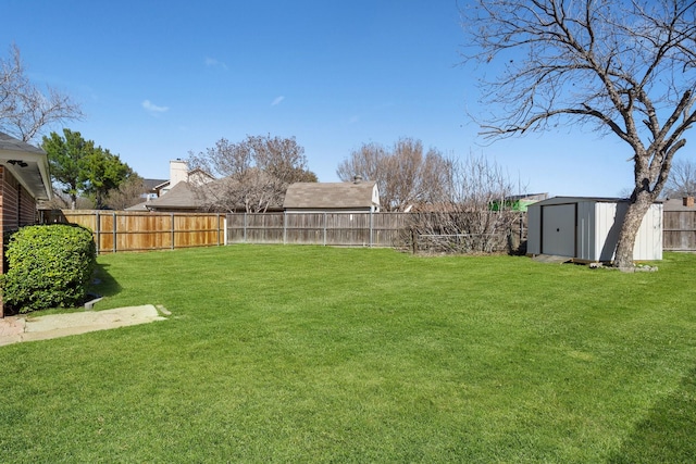 view of yard with a storage shed, an outdoor structure, and a fenced backyard