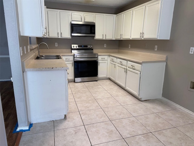 kitchen with light tile patterned flooring, appliances with stainless steel finishes, and a sink