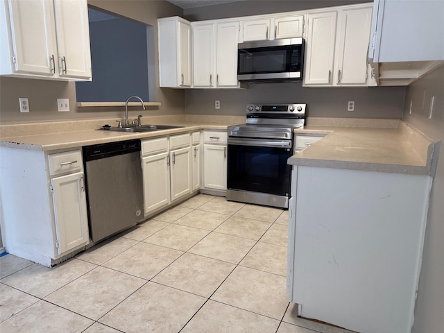 kitchen featuring light tile patterned floors, white cabinetry, stainless steel appliances, and a sink